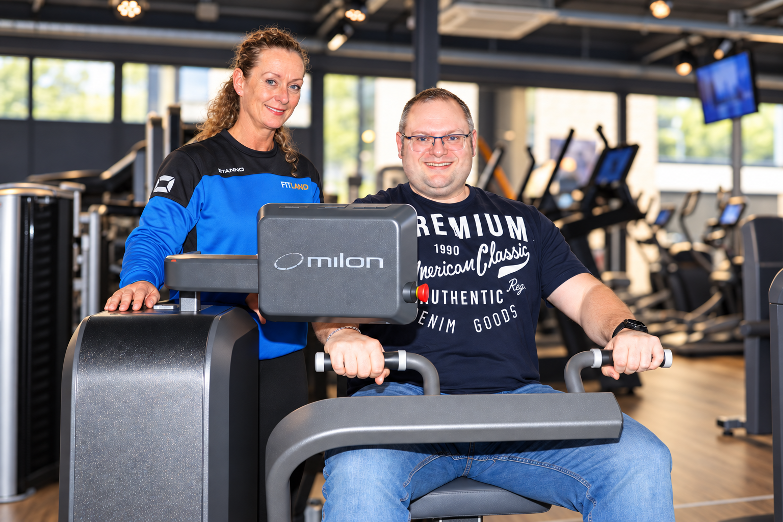 Coach begeleidt een sporter bij de Milon Cirkel van Fitland Gemert